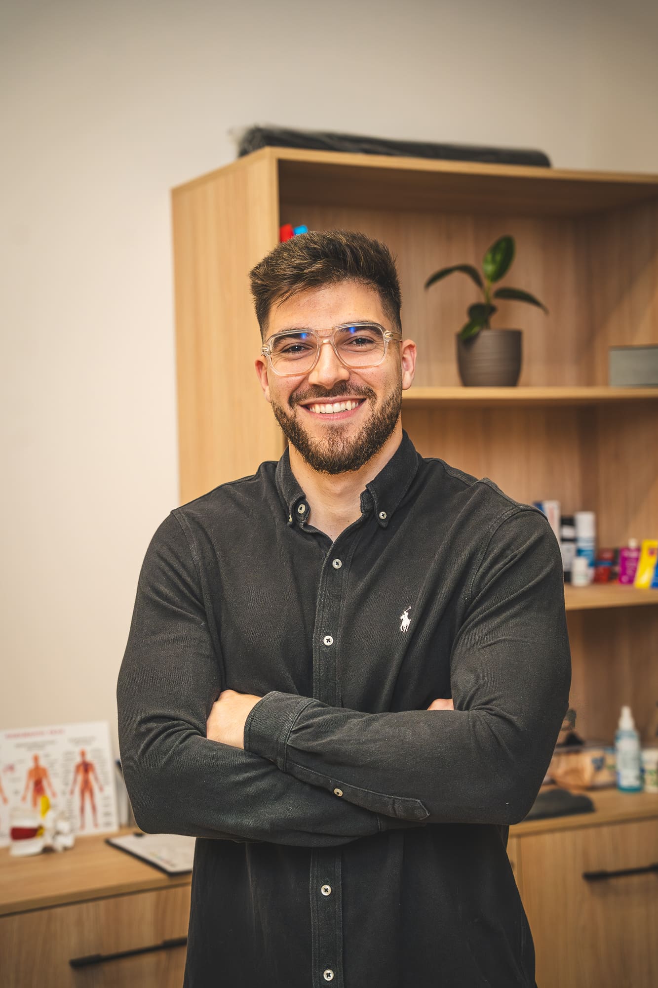Man standing in a room with wooden shelves and various items